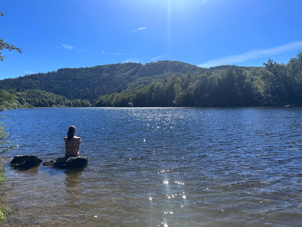 Rilassarsi al lago durante un'avventura di packrafting nell'Eifel, in Germania
